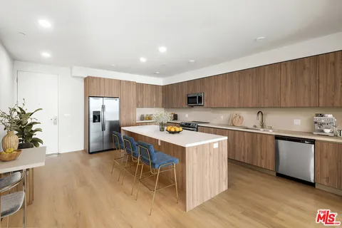 a kitchen with a sink a counter top space and stainless steel appliances