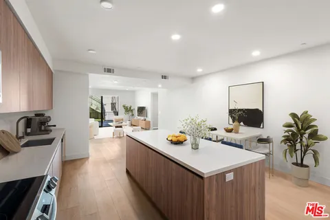 a kitchen with a sink stove and wooden floor
