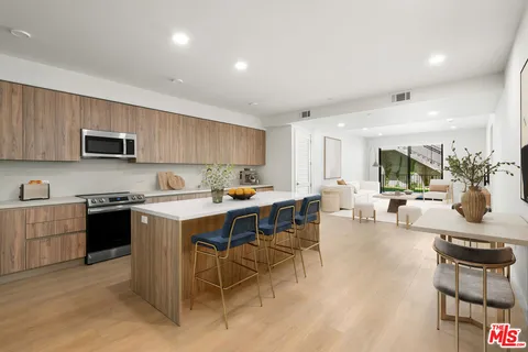 a kitchen with a table chairs microwave and cabinets