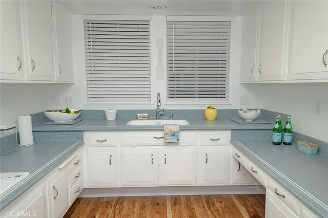 a kitchen with granite countertop white cabinets and white appliances