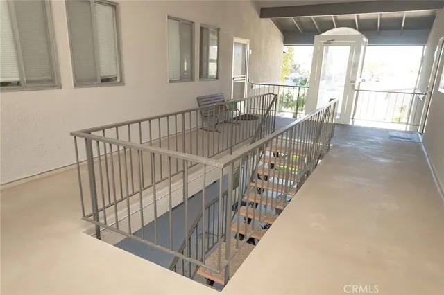 a view of staircase with railing and a chandelier