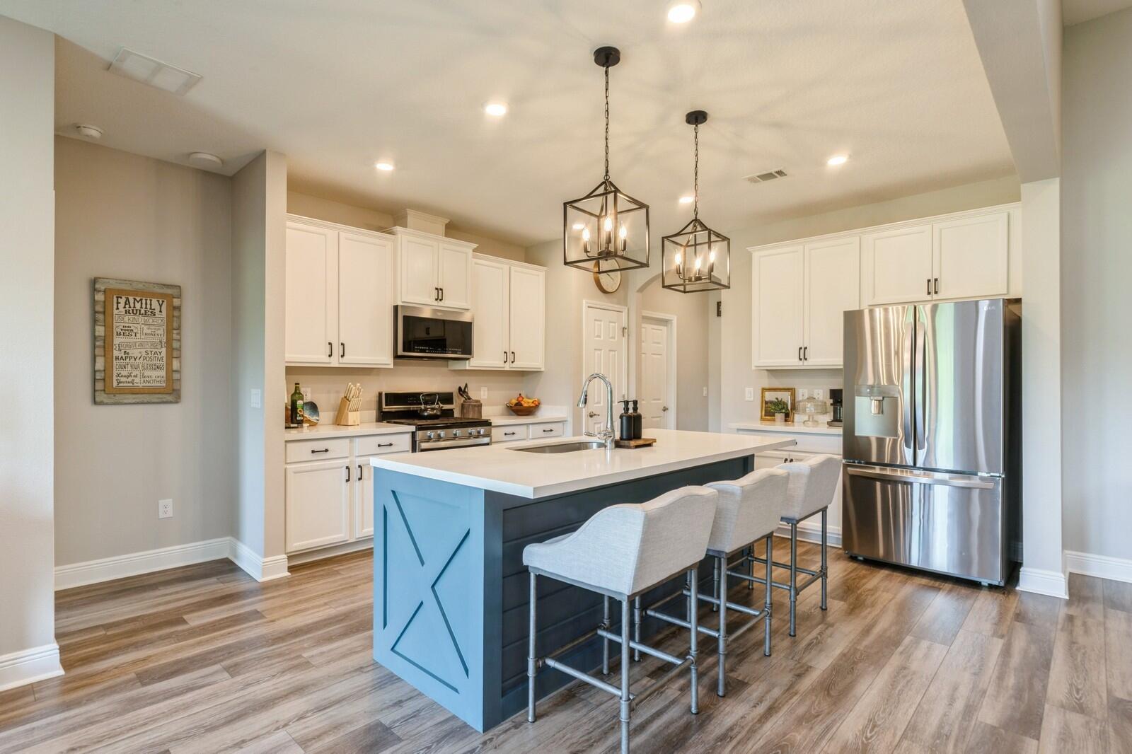 254 Concert Court Freeport, FL 32439 - Photo 12 of 69 a kitchen with stainless steel appliances a dining table chairs stove and refrigerator