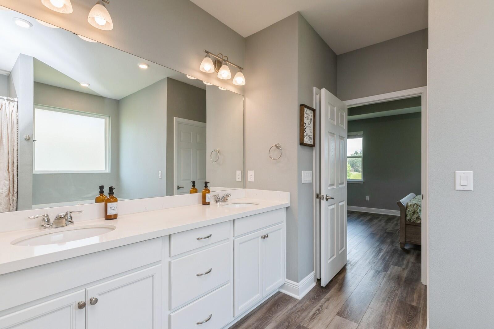 254 Concert Court Freeport, FL 32439 - Photo 21 of 69 a en suite bathroom with a double vanity sink and mirror
