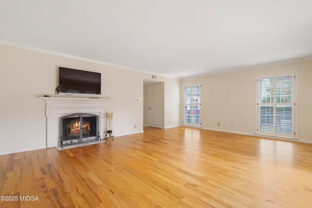 a view of empty room with wooden floor and fireplace