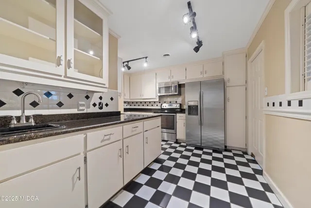 a kitchen with granite countertop stainless steel appliances a sink and cabinets