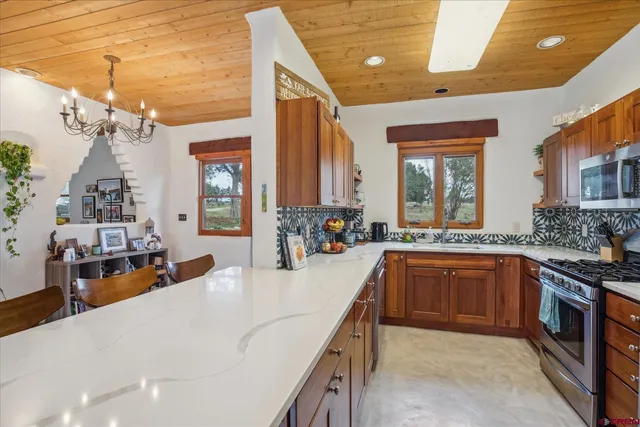 a large kitchen with stainless steel appliances granite countertop a sink and cabinets