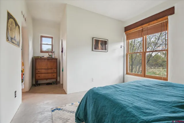 a bedroom with a bed and a large window