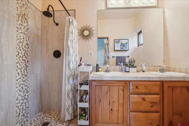 a bathroom with a sink vanity granite and a shower