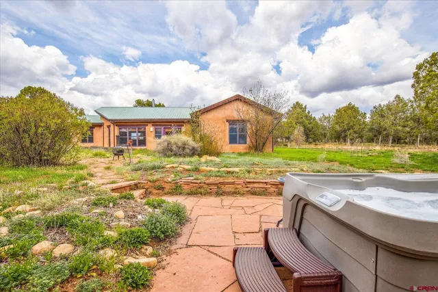 a view of a patio with a table and chairs under an umbrella
