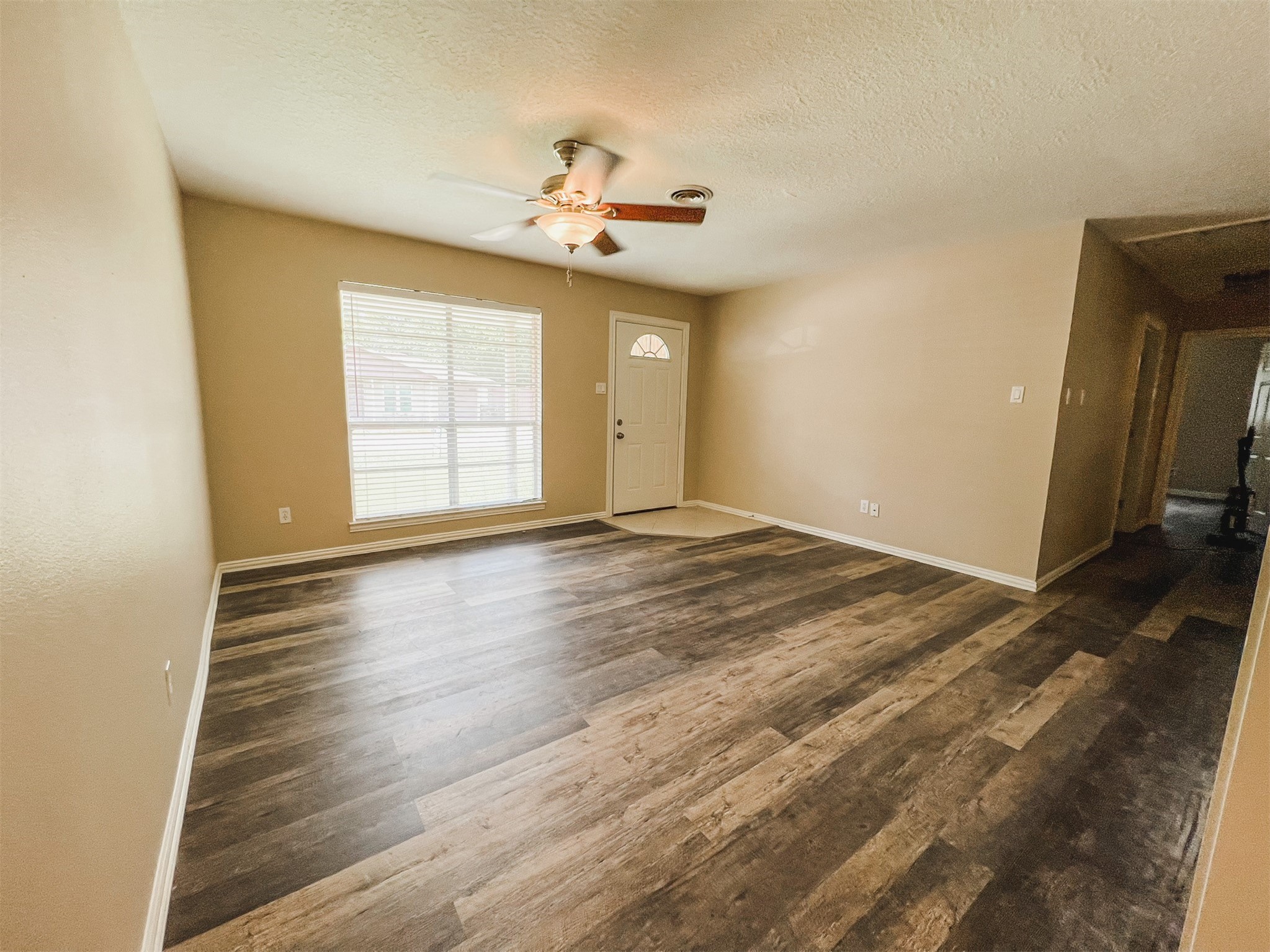 724 Gubert Lane Alvin, TX 77511 - Photo 6 of 15 an empty room with wooden floor chandelier fan and windows