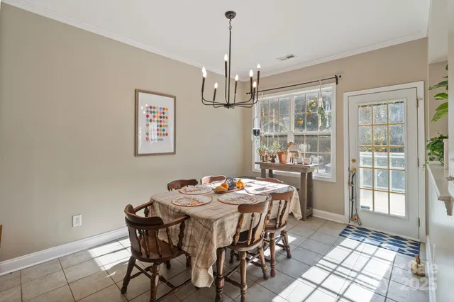 a dining room with furniture a chandelier and window