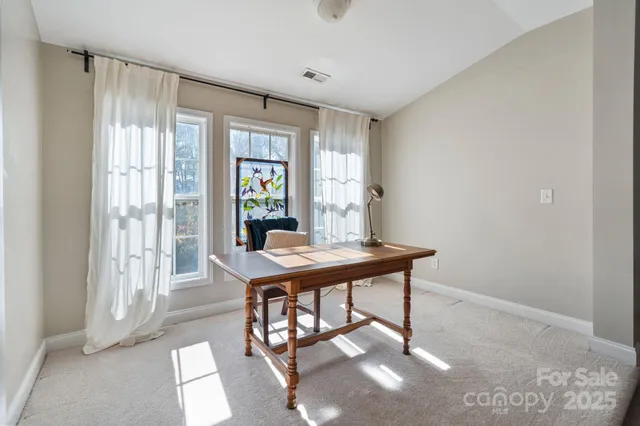 a view of a workspace with furniture and a window