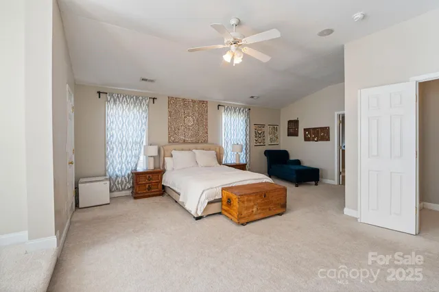 a spacious bedroom with a bed and ceiling fan
