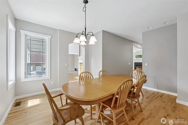 a dining room with furniture a chandelier and wooden floor