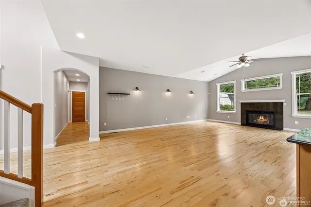a view of empty room with wooden floor and fireplace
