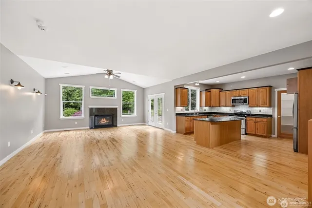 a kitchen with kitchen island a large counter top space and stainless steel appliances