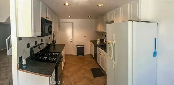 a kitchen with stainless steel appliances granite countertop a refrigerator and a stove