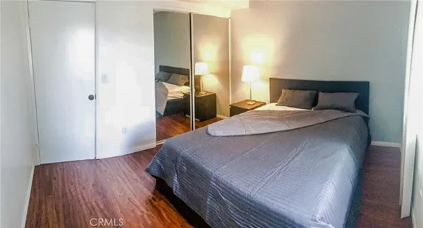 a bedroom with a bed and wooden floor