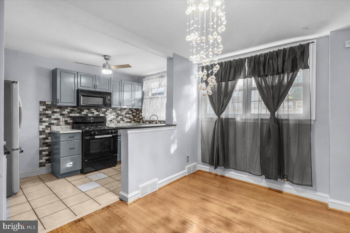 7823 Forrest Avenue Philadelphia, PA 19150 - Photo 3 of 27 a kitchen with stainless steel appliances a refrigerator and a stove top oven