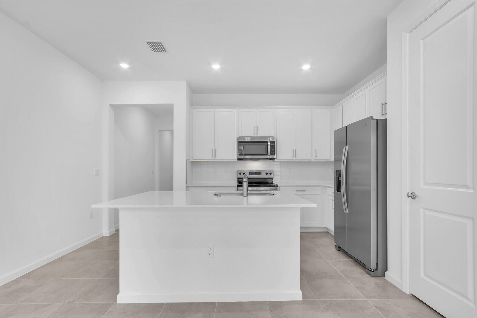 287 Southwest Sally Way Stuart, FL 34997 - Photo 13 of 41 a kitchen with stainless steel appliances a refrigerator a stove a sink and white cabinets