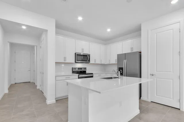 a kitchen with stainless steel appliances a refrigerator stove microwave and sink