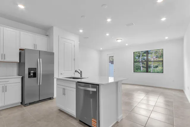 a kitchen with stainless steel appliances granite countertop a refrigerator and a sink