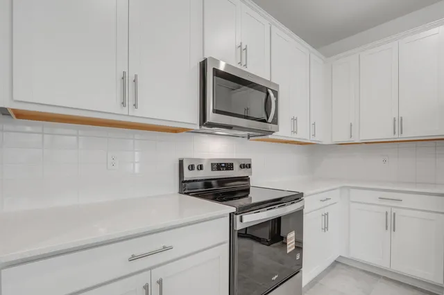 a kitchen with white cabinets stainless steel appliances and sink