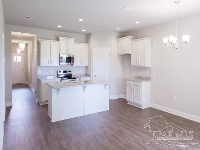 7787 Burnside Loop Pensacola, FL 32526 - Photo 8 of 32 a kitchen with white cabinets and refrigerator