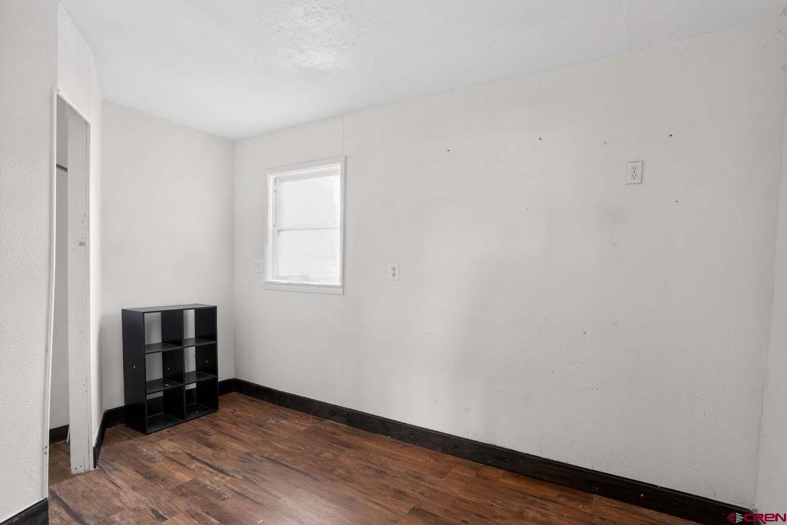 501 East 2nd Street Cortez, CO 81321 - Photo 11 of 30 a view of an empty room with wooden floor and a window