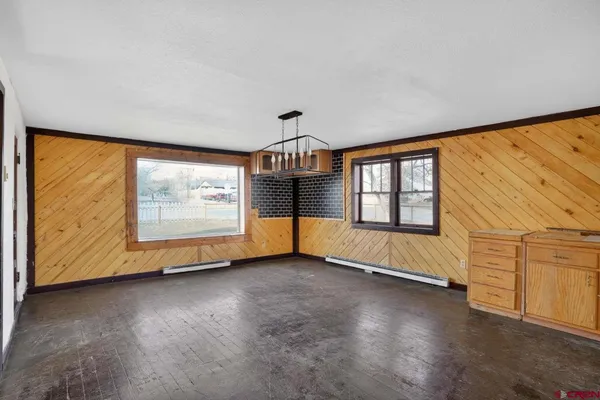 a view of empty room with wooden floor and window