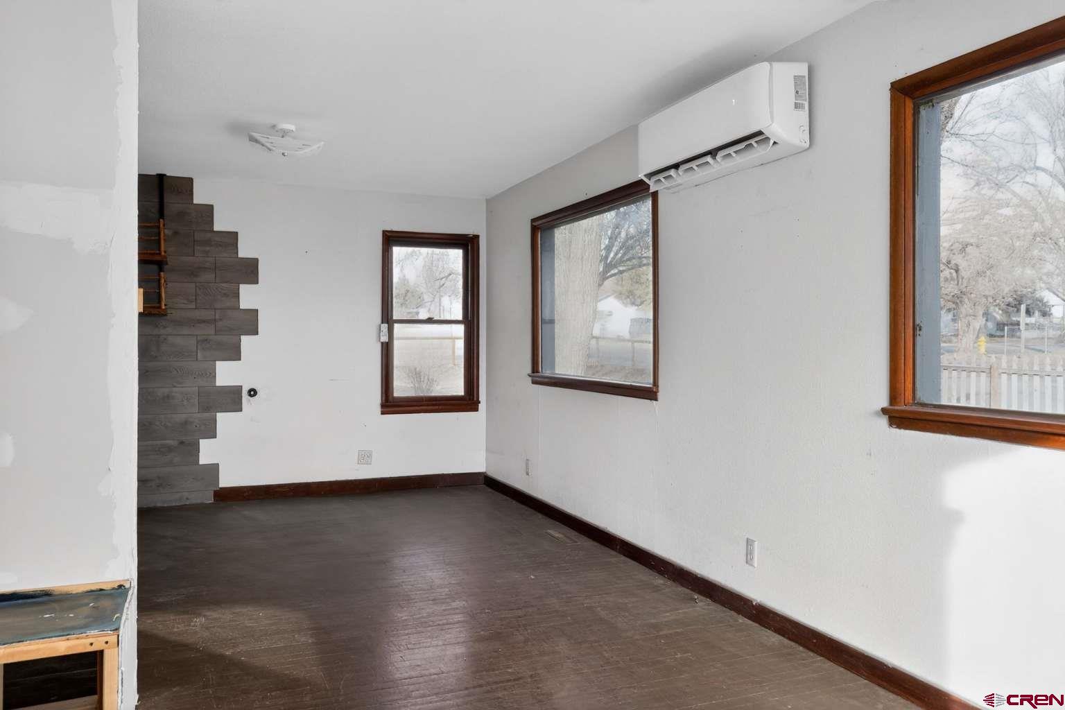 501 East 2nd Street Cortez, CO 81321 - Photo 10 of 30 an empty room with wooden floor and windows