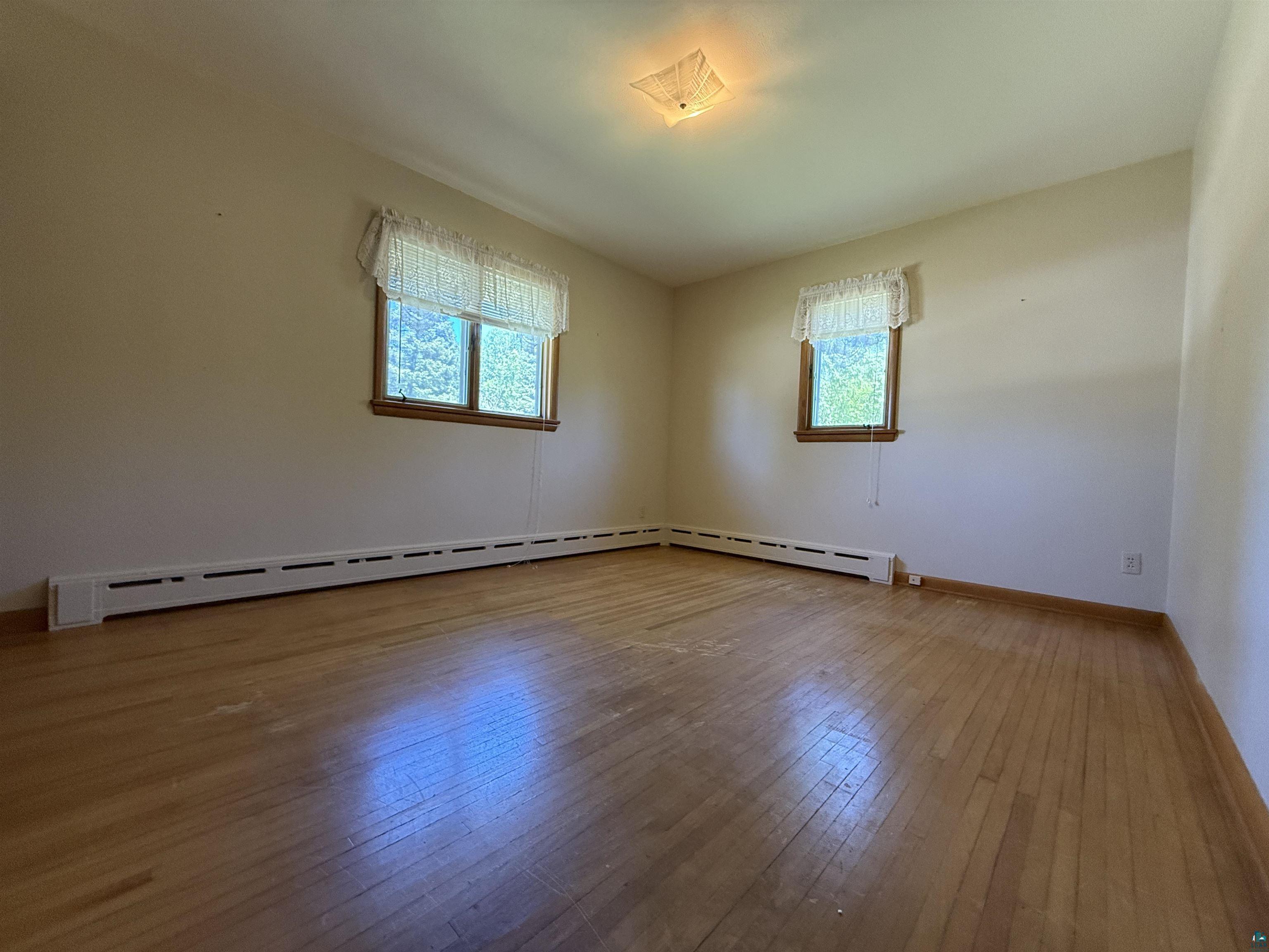 607 3rd Street Northeast Chisholm, MN 55719 - Photo 13 of 32 Hardwood flooring throughout, illuminated by natural light from two windows