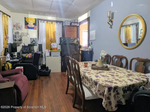 a dining room with furniture a mirror and wooden floor