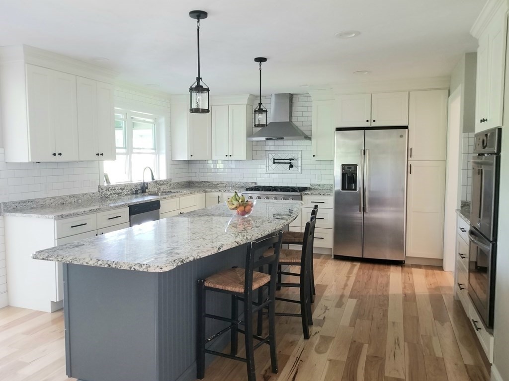 7 Dean Farm Road Sutton, MA 01590 - Photo 5 of 33 a kitchen with stainless steel appliances granite countertop a sink a stove a refrigerator and island with wooden floor