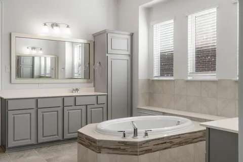 a bathroom with a tub sink and mirror