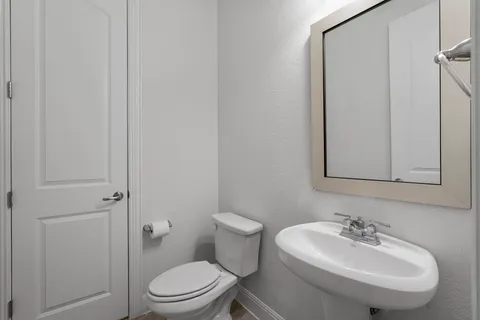 a bathroom with a sink a toilet and mirror