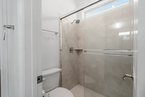 a bathroom with a toilet and a shower