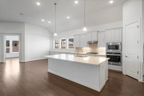 a kitchen with stainless steel appliances granite countertop a sink a stove and a refrigerator