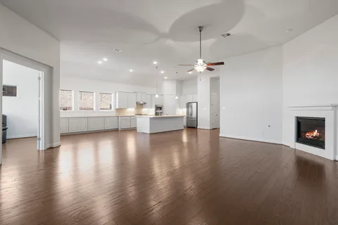 a view of a room with wooden floor and a kitchen