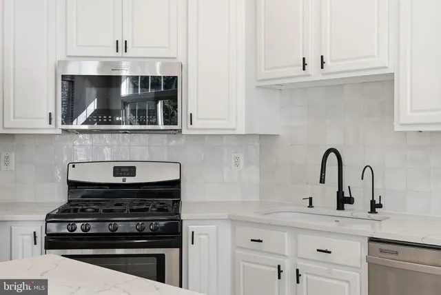 a kitchen with a stove and white cabinets