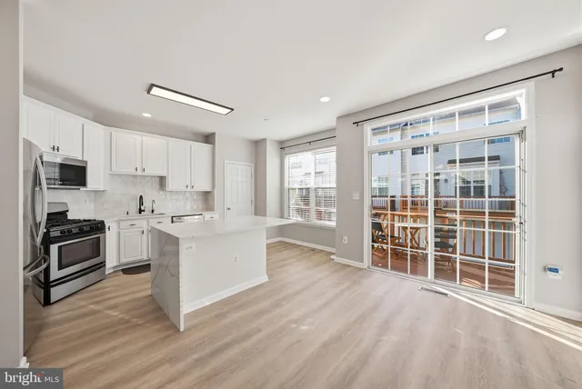 a large kitchen with a large window and stainless steel appliances