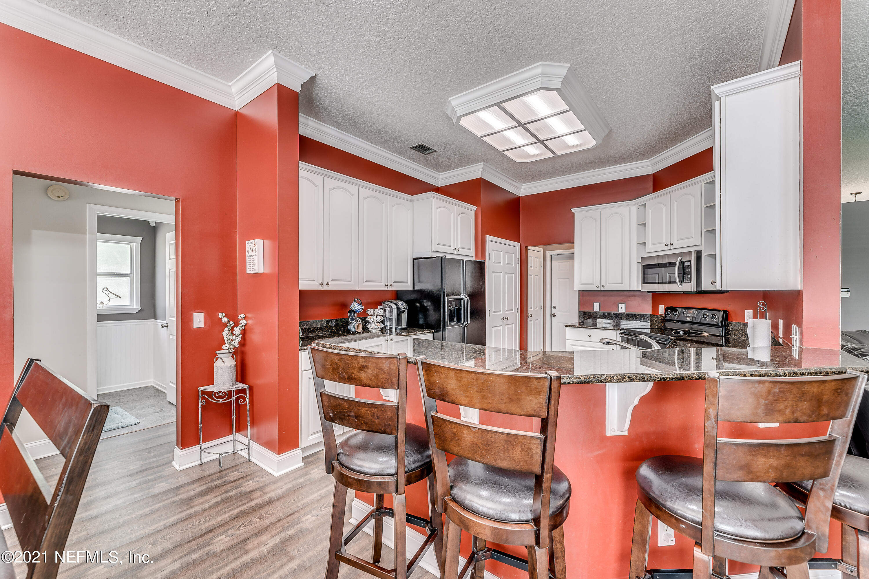 1123 Cactus Cut Road Middleburg, FL 32068 - Photo 31 of 66 a kitchen with stainless steel appliances kitchen island granite countertop a dining table chairs and a refrigerator