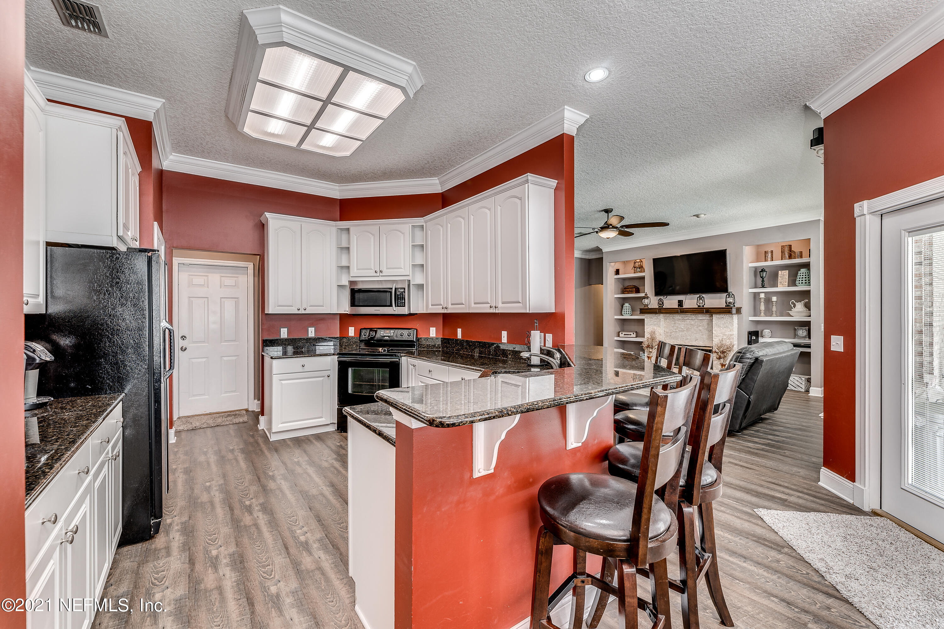 1123 Cactus Cut Road Middleburg, FL 32068 - Photo 32 of 66 a kitchen with stainless steel appliances kitchen island granite countertop a table chairs stove and refrigerator