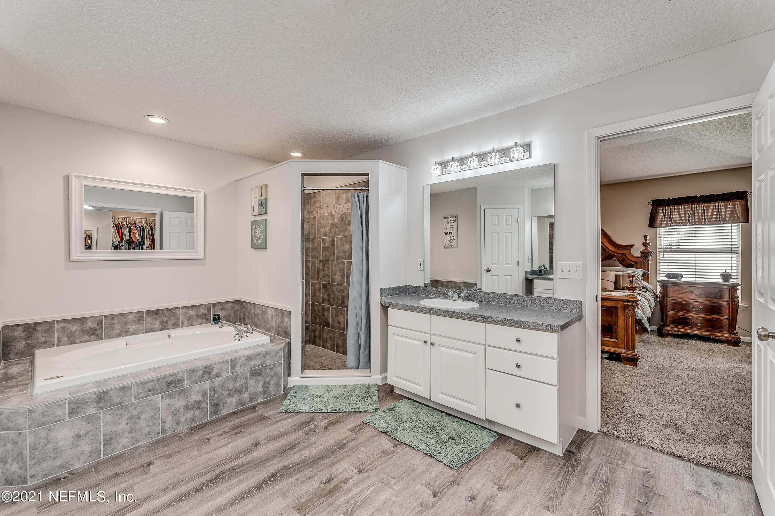 1123 Cactus Cut Road Middleburg, FL 32068 - Photo 44 of 66 a bathroom with a tub a double vanity sink and a large mirror