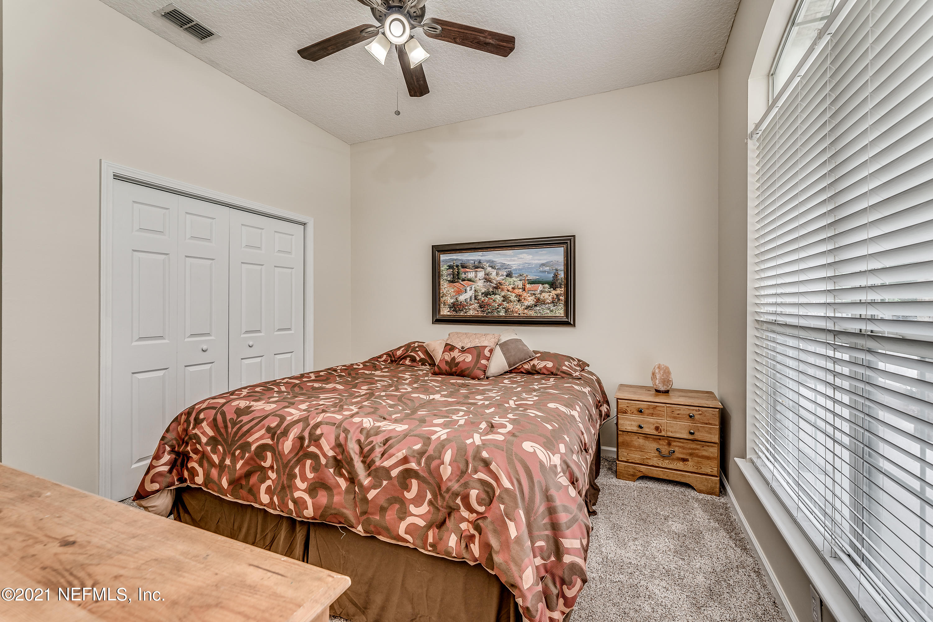 1123 Cactus Cut Road Middleburg, FL 32068 - Photo 47 of 66 a bedroom with a bed and a chandelier