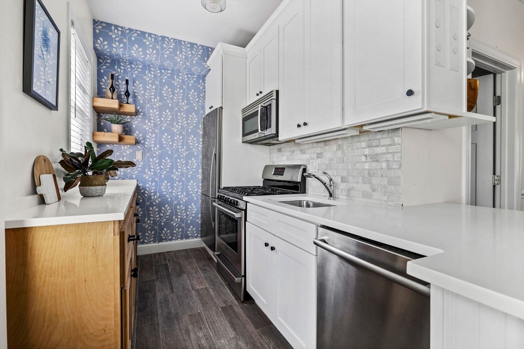296 East 8th Street, Unit 3 Boston, MA 02127 - Photo 11 of 29 a kitchen with stainless steel appliances a sink stove and cabinets
