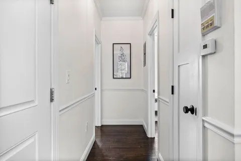 a view of a hallway with wooden floor and entryway