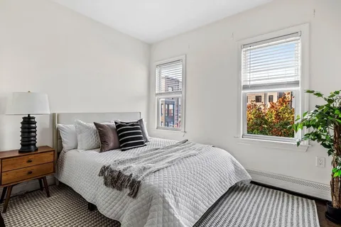 a large bed sitting in a bedroom next to a window