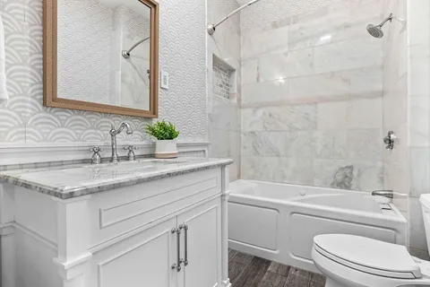 a bathroom with a granite countertop sink toilet and shower