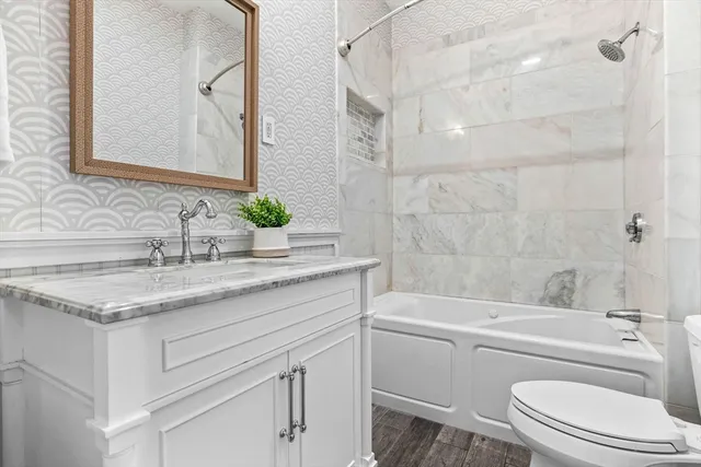 a bathroom with a granite countertop sink toilet and shower
